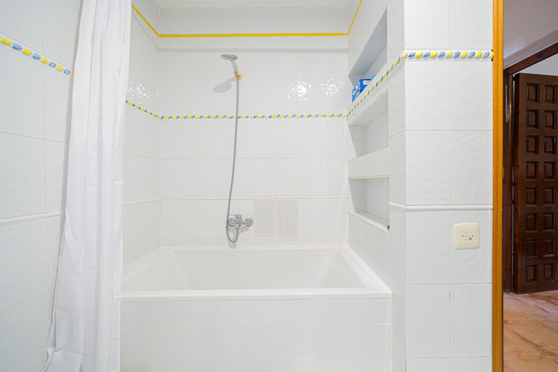 Een badkamer met witte tegels en een ligbad en douche van Villa Fave in Javea 