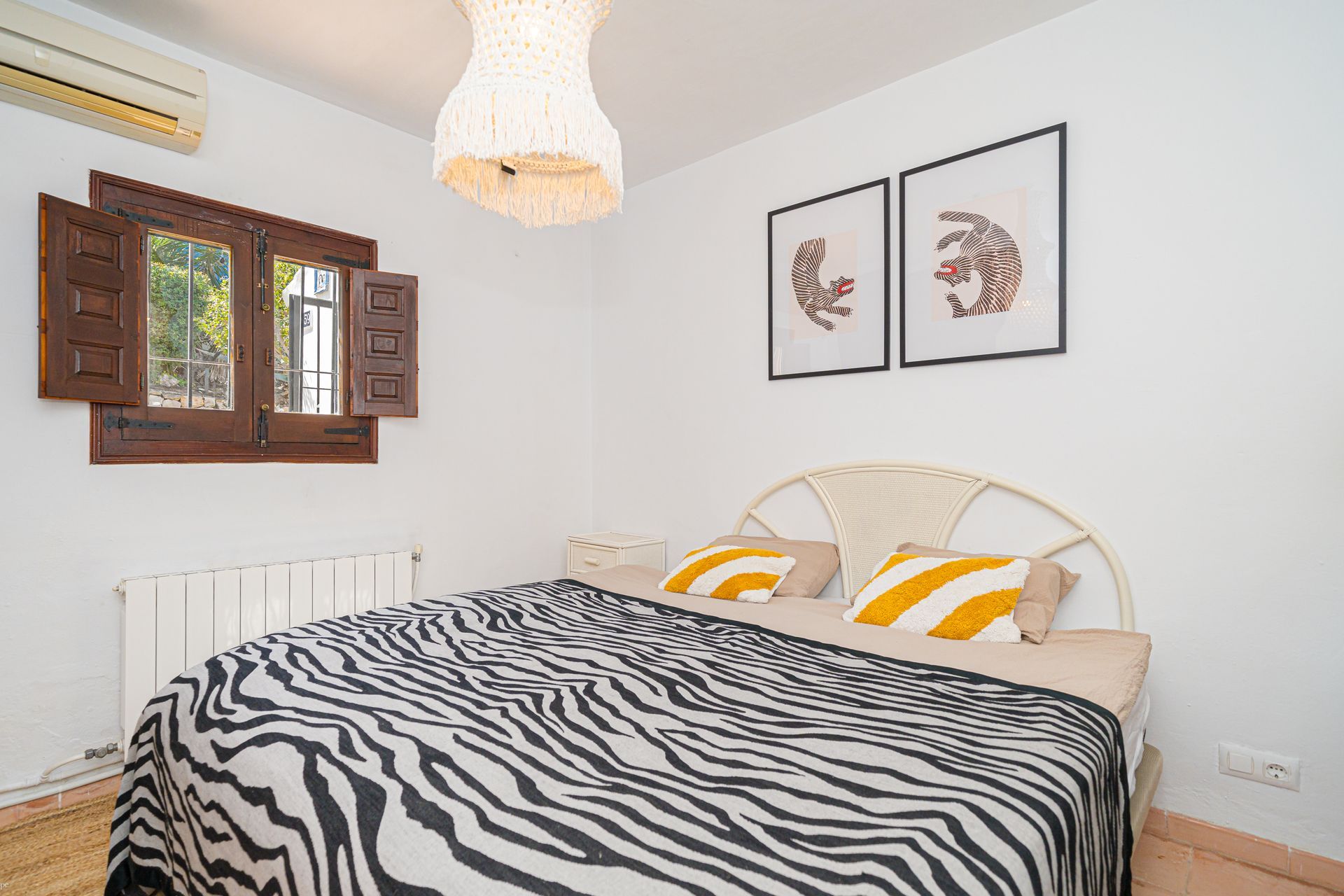 Een slaapkamer met een bed met zebraprint en twee schilderijen aan de muur van Villa Fave in Javea