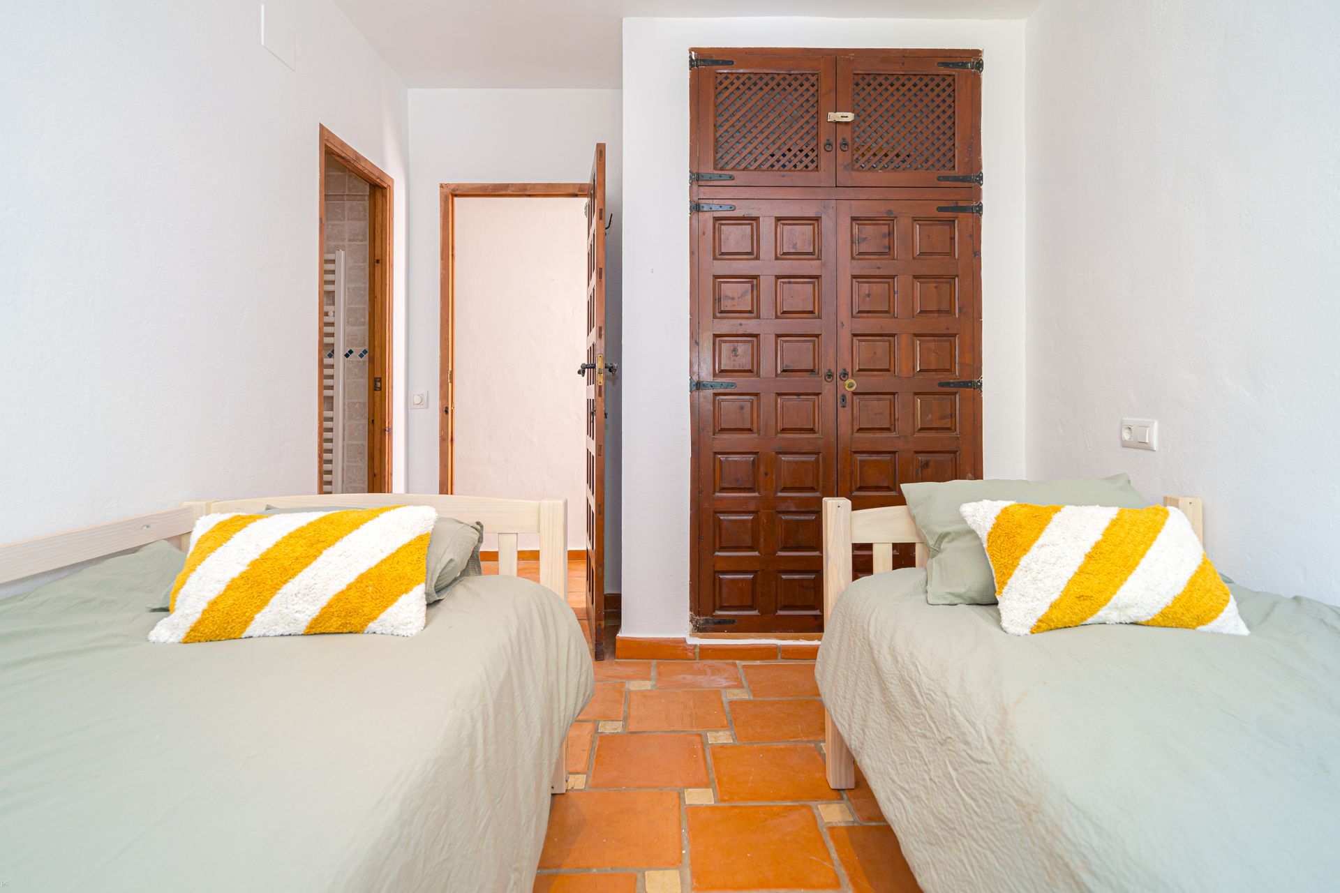 Een slaapkamer met twee bedden en een houten deur van Villa Fave in Javea
