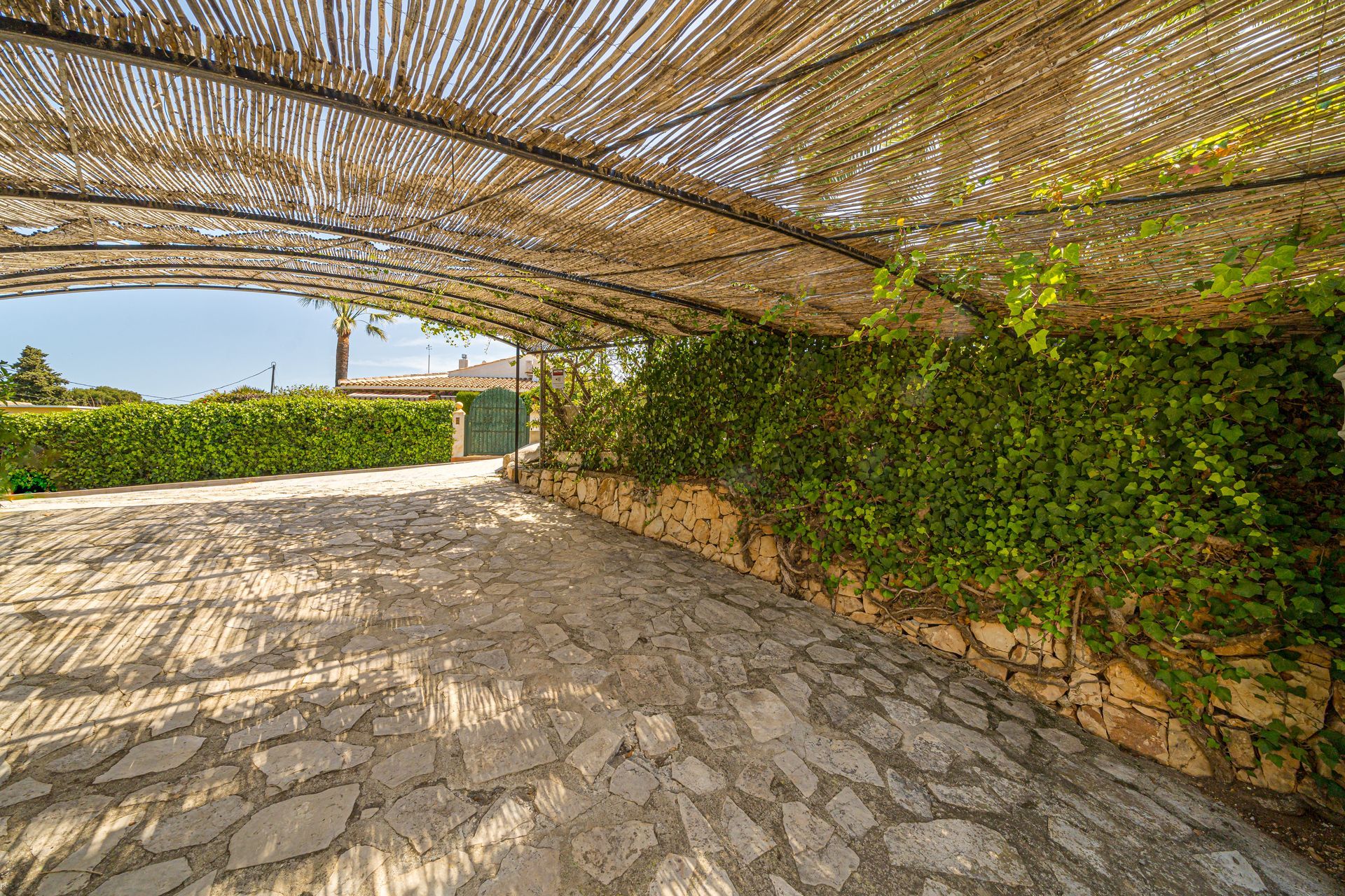 Een stenen loopbrug met een baldakijn erboven van Villa Fave in Javea