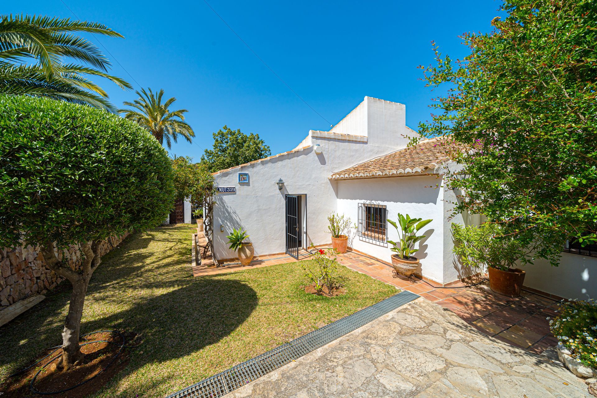 Een wit huis is omgeven door bomen en struiken van Villa Fave in Javea