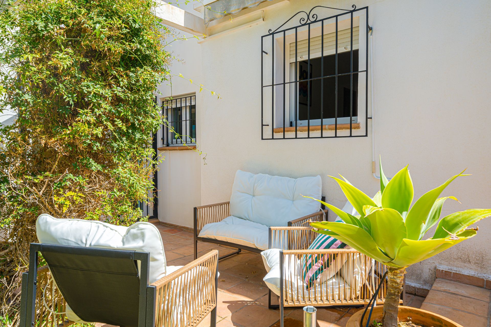 Een patio met een bank en stoelen voor een raam. Villa Fave Javea El Tosalet