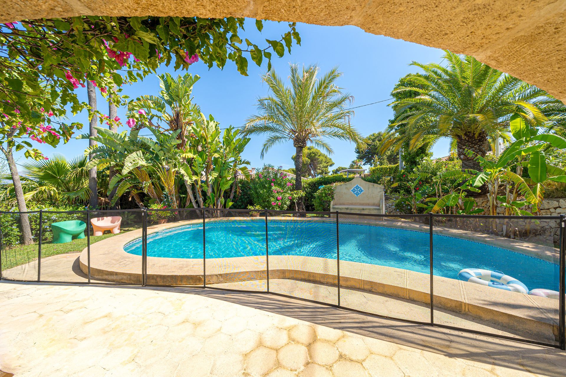 Een groot zwembad omgeven door palmbomen op een zonnige dag bij Villa Fave, El Tosalet, Javea