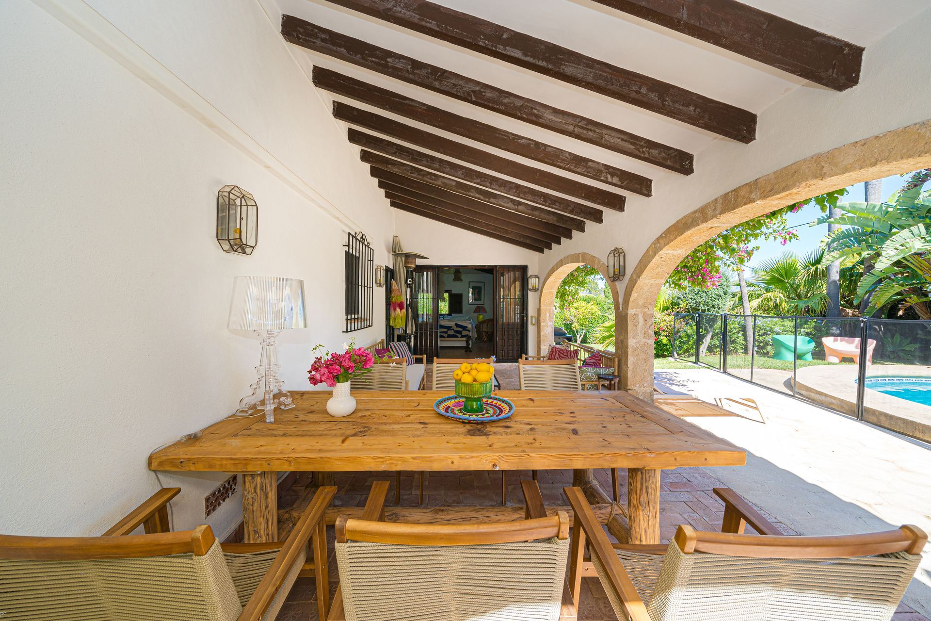 Een terras met een houten tafel en stoelen