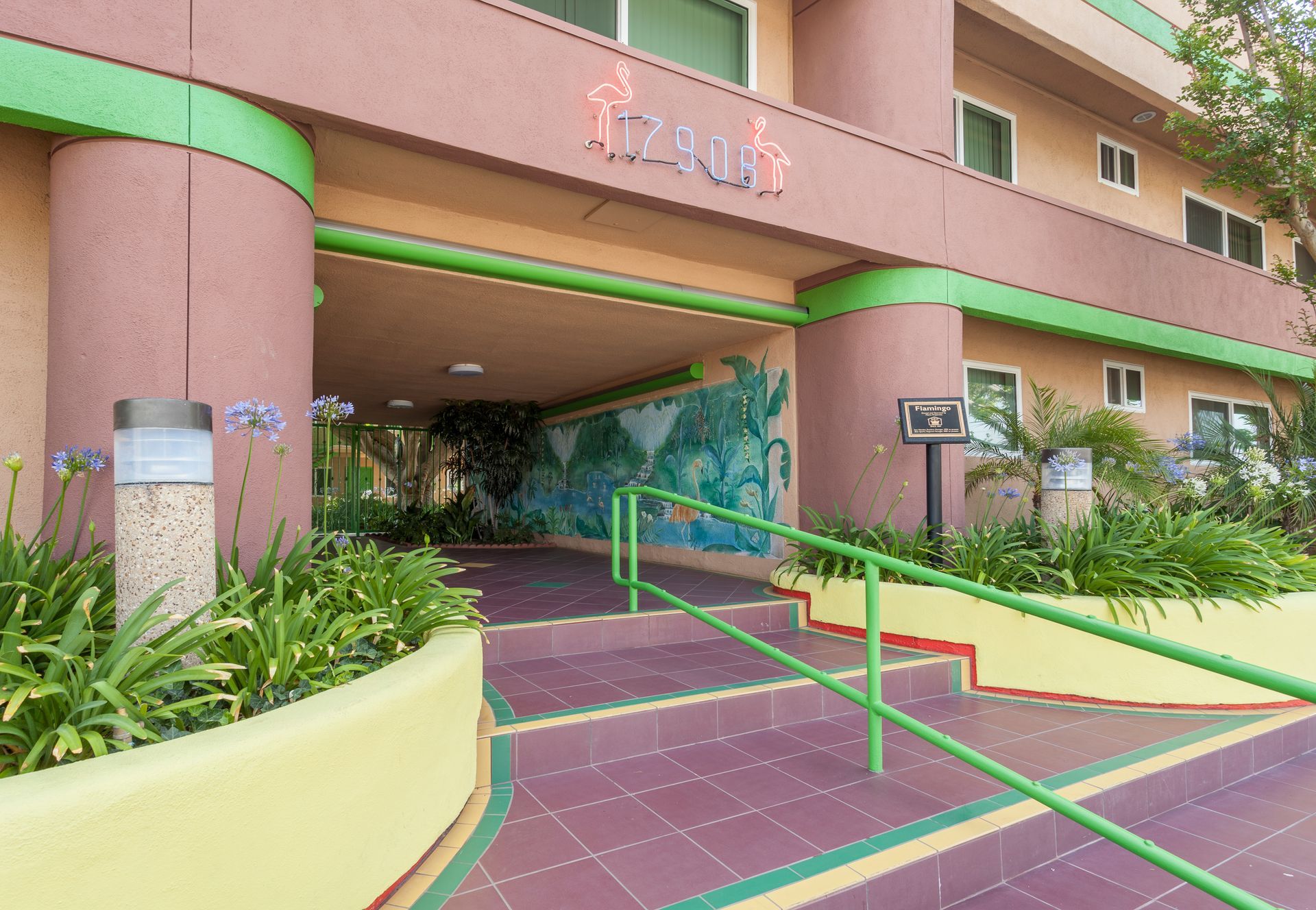 A building with a green railing and stairs leading up to it