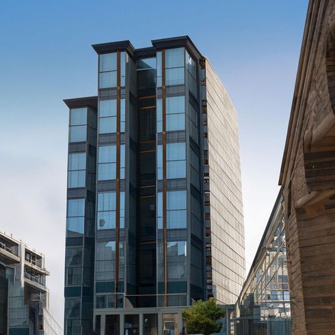 Modern glass office tower with blue windows under a clear sky