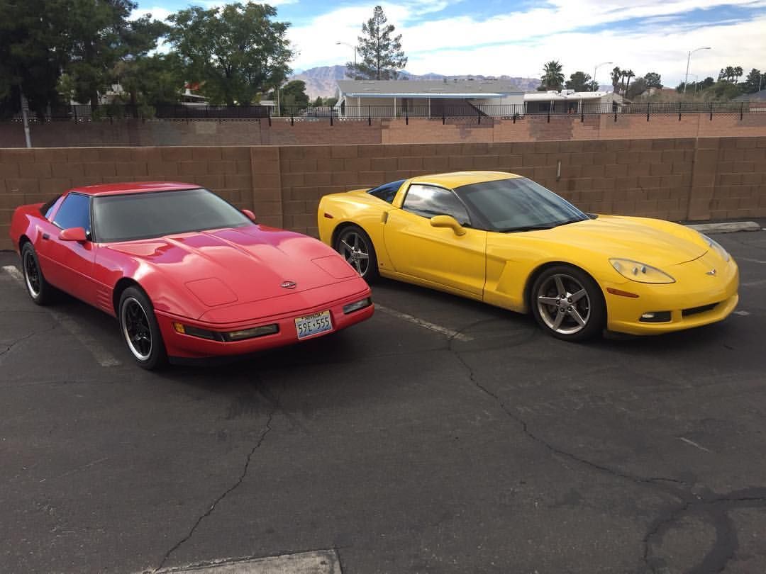 Two sports cars, one red and one yellow, parked side by side in a lot.