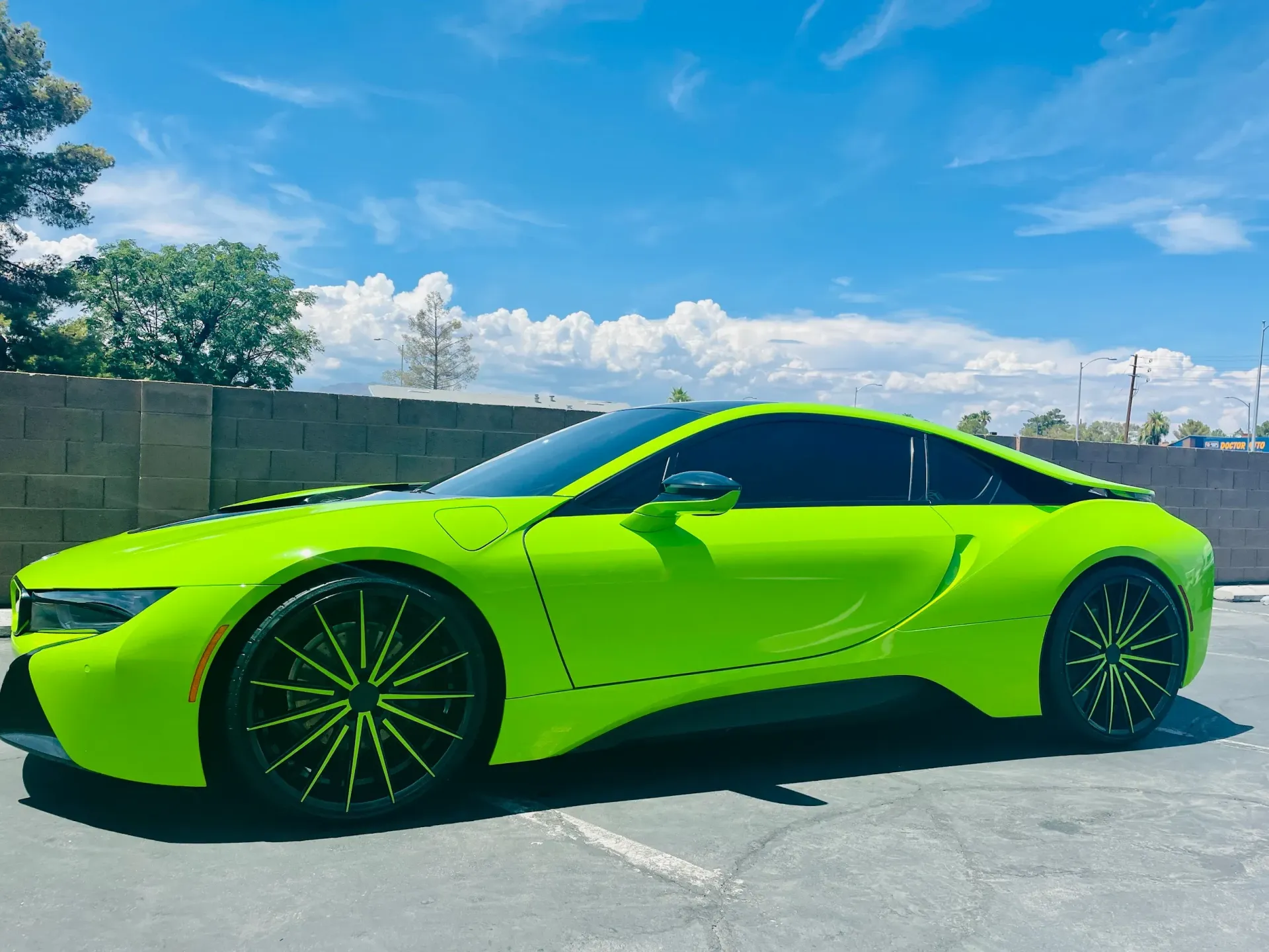 Bright lime green sports car parked outdoors under a blue sky.