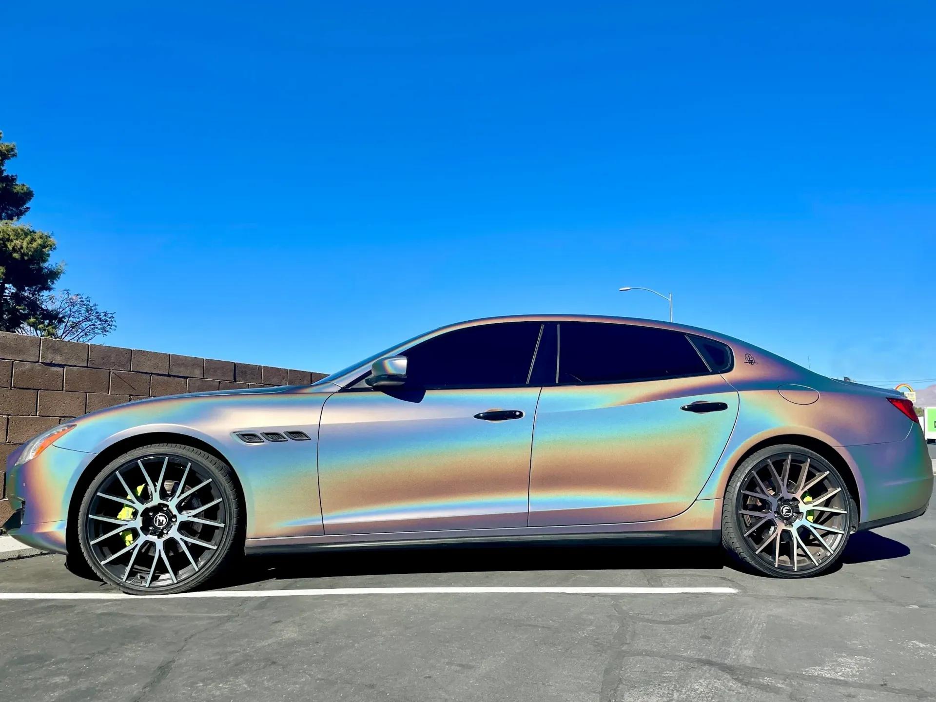 Silver sports coupe parked on a roadside under a clear blue sky