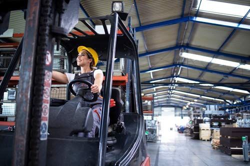 Woman in a warehouse operating a forklift
