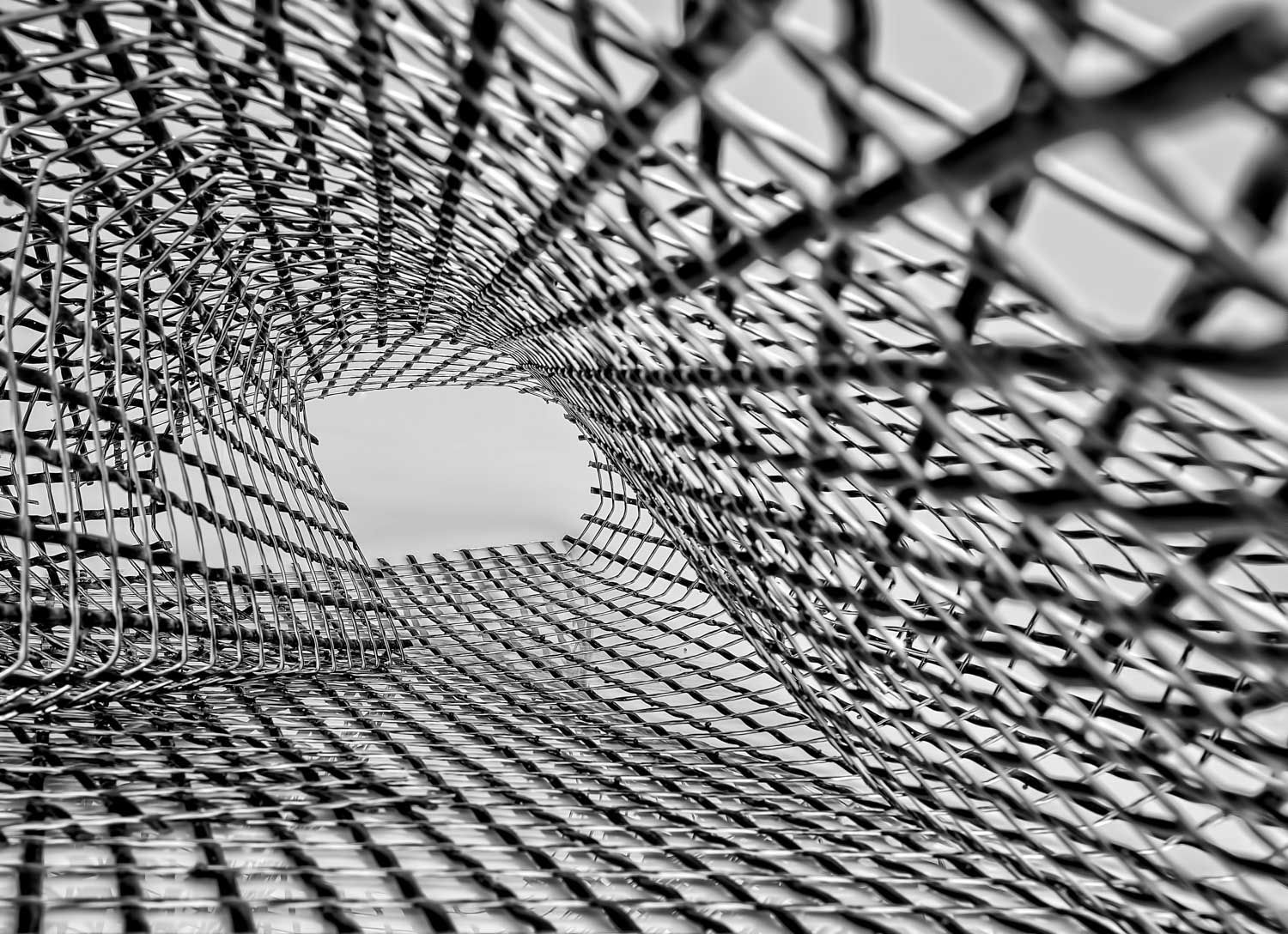 Black and white perspective shot inside a square metal cage