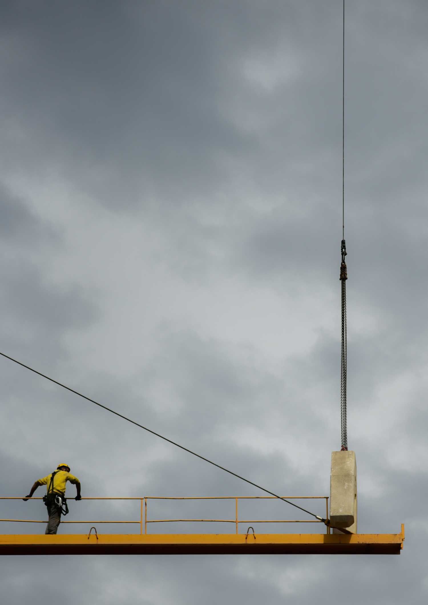 Worker in yellow safety gear on a yellow beam