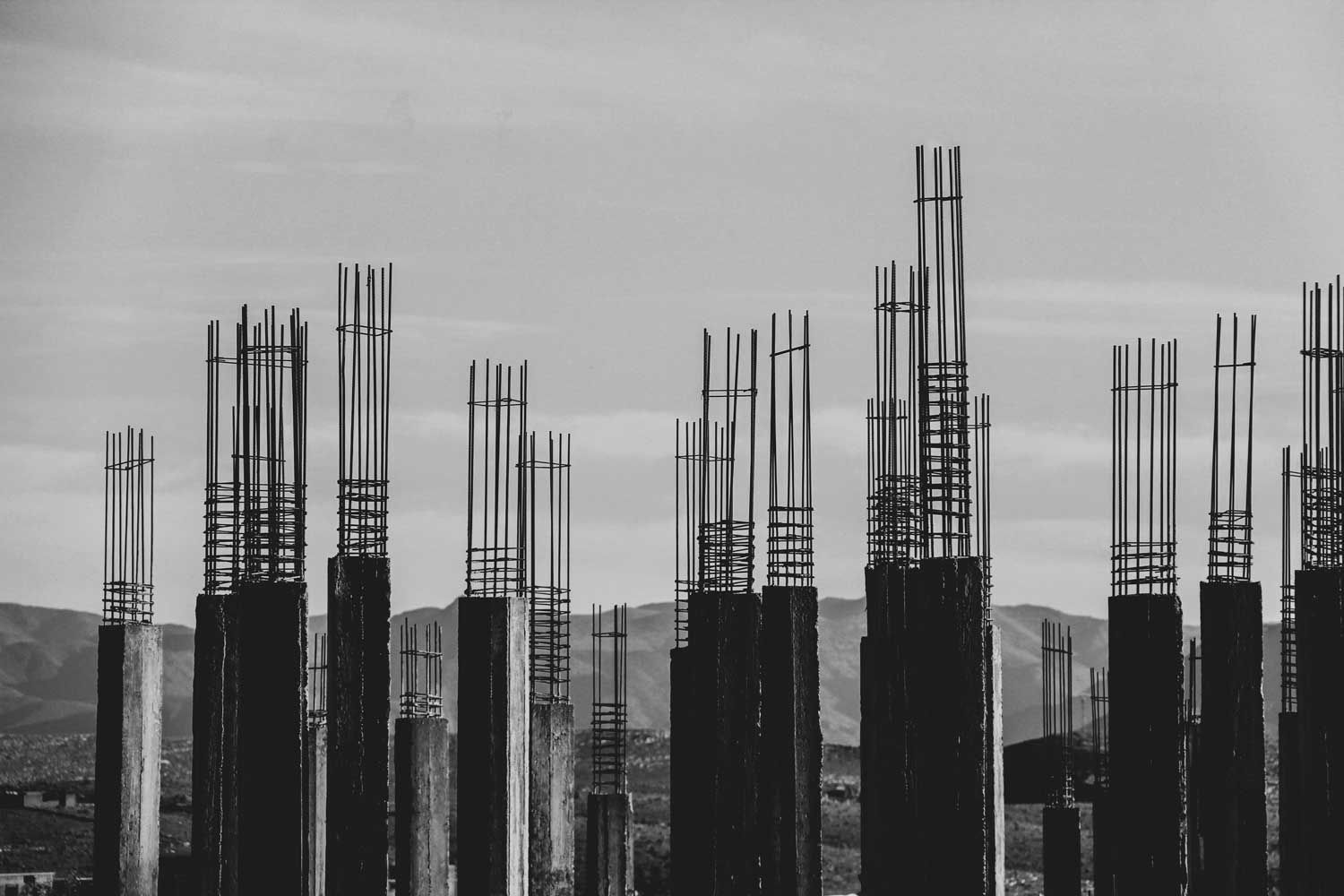 Construction site with concrete pillars and exposed rebar