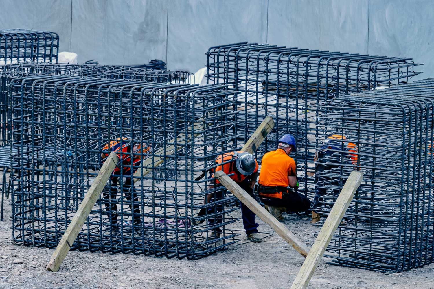 Construction workers building steel reinforcement cages on a construction site