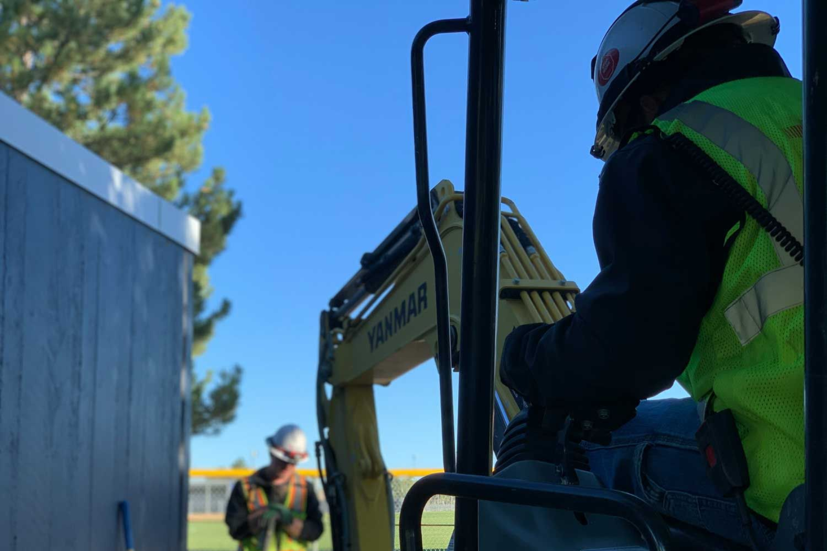 Worker operating a yellow excavator