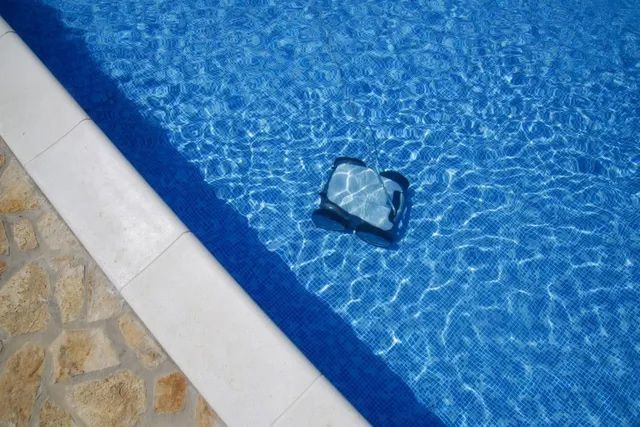 Cleaning The Pool Floor With An Underwater Vacuum Cleaner — Gloucester Outdoor Solutions In Stroud, NSW