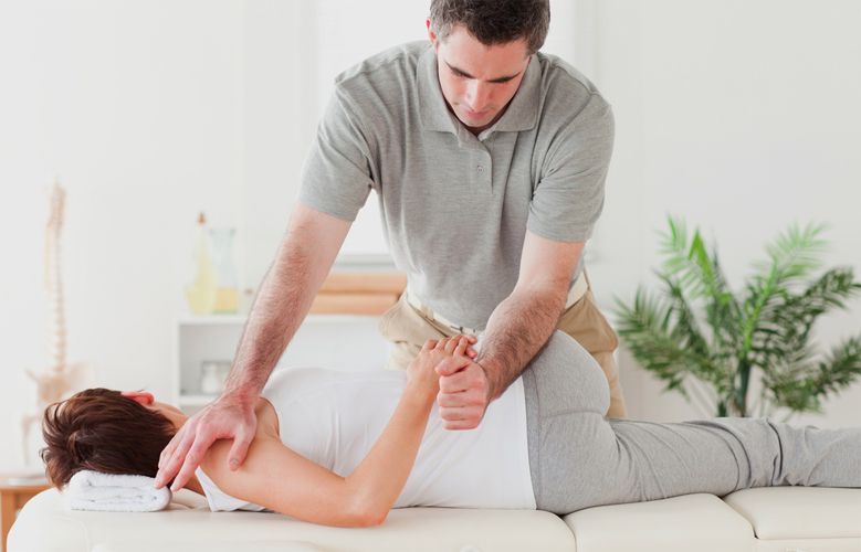 A man is giving a woman a massage on a table.