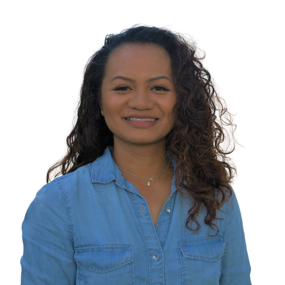 A woman with curly hair is wearing a blue shirt and smiling