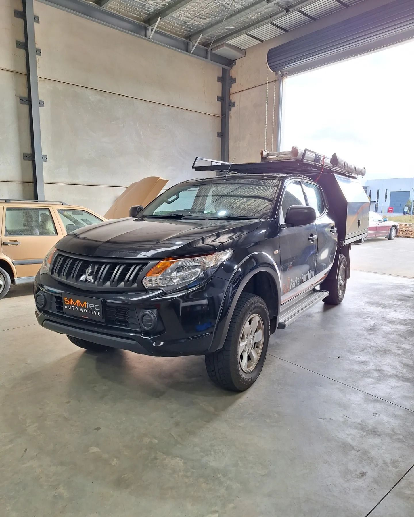 A black pickup truck is parked in a garage.