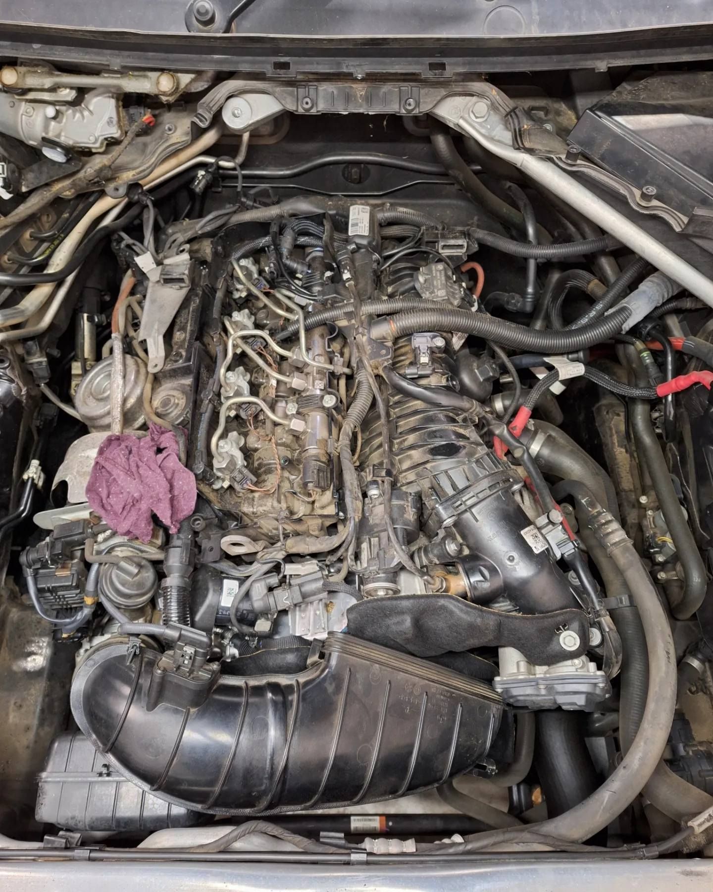 A close up of the engine of a car with the hood open.