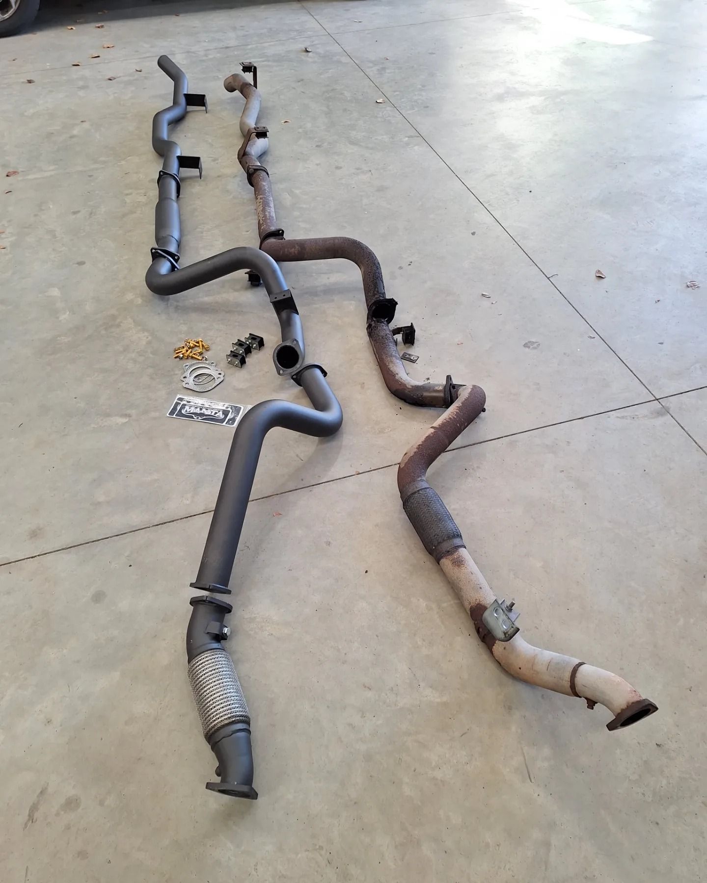 A bunch of exhaust pipes are laying on the ground