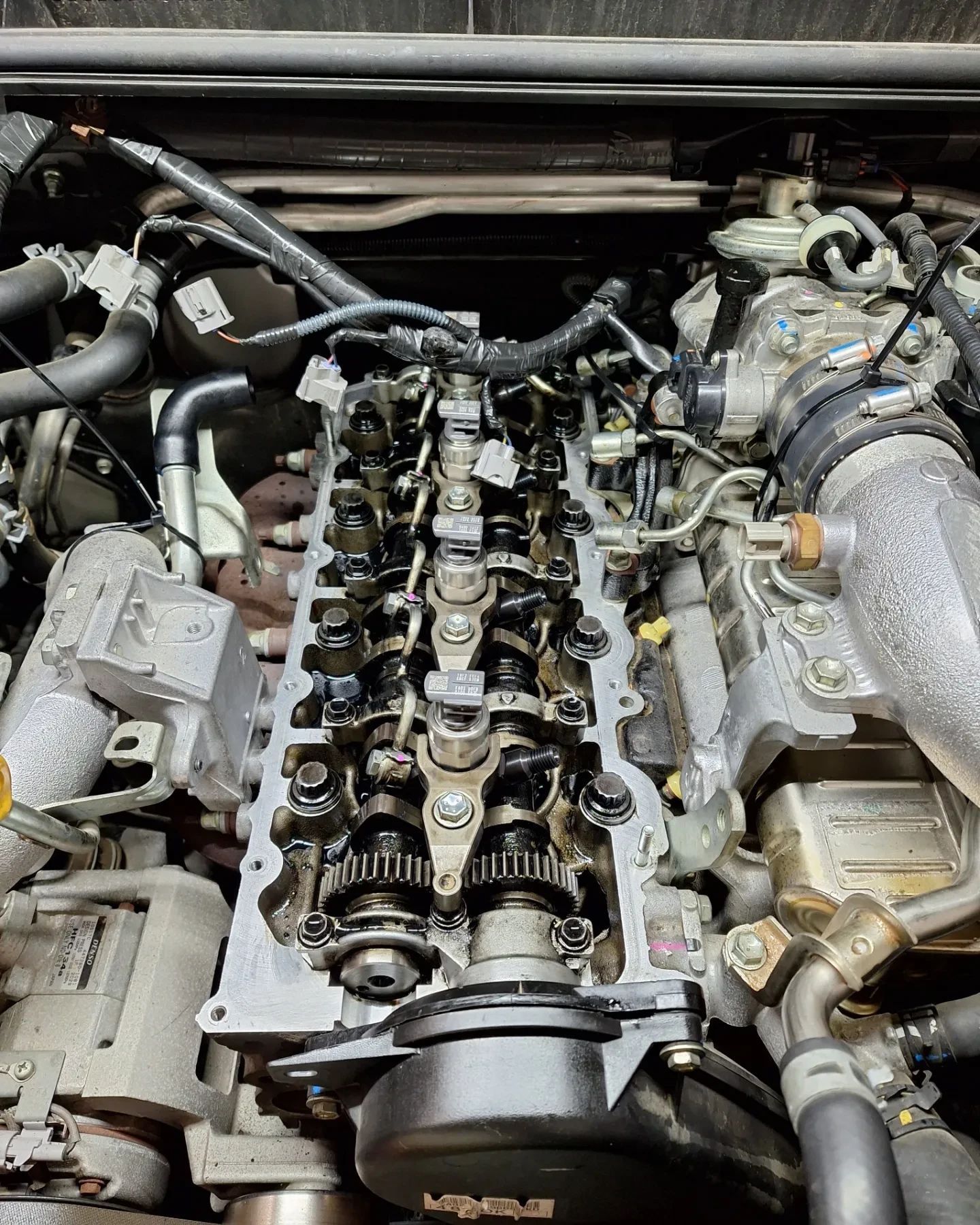 A close up of a car engine with the head removed.