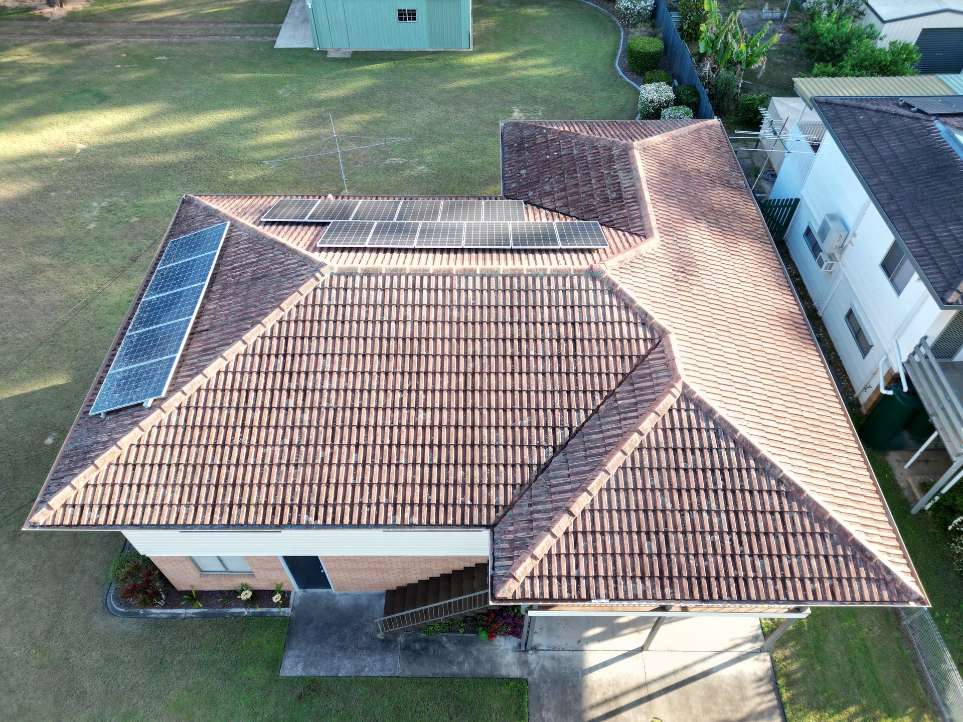 An aerial view of a house with solar panels on the roof.