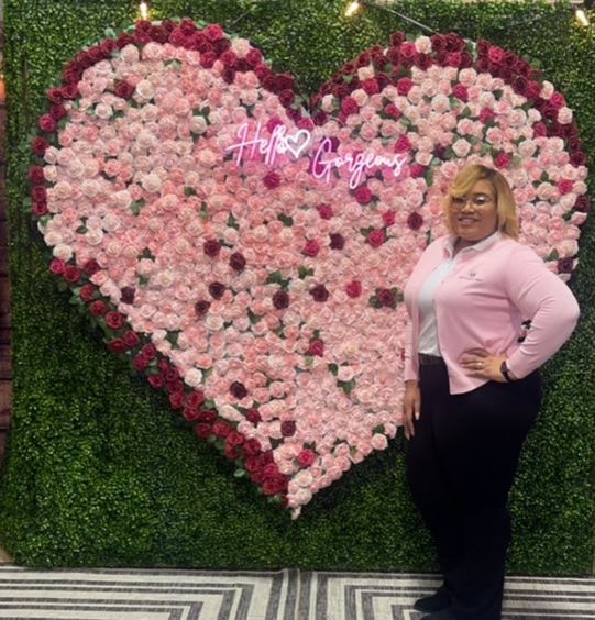 Lex Luxury Travel team member promoting travel services at a branded event backdrop