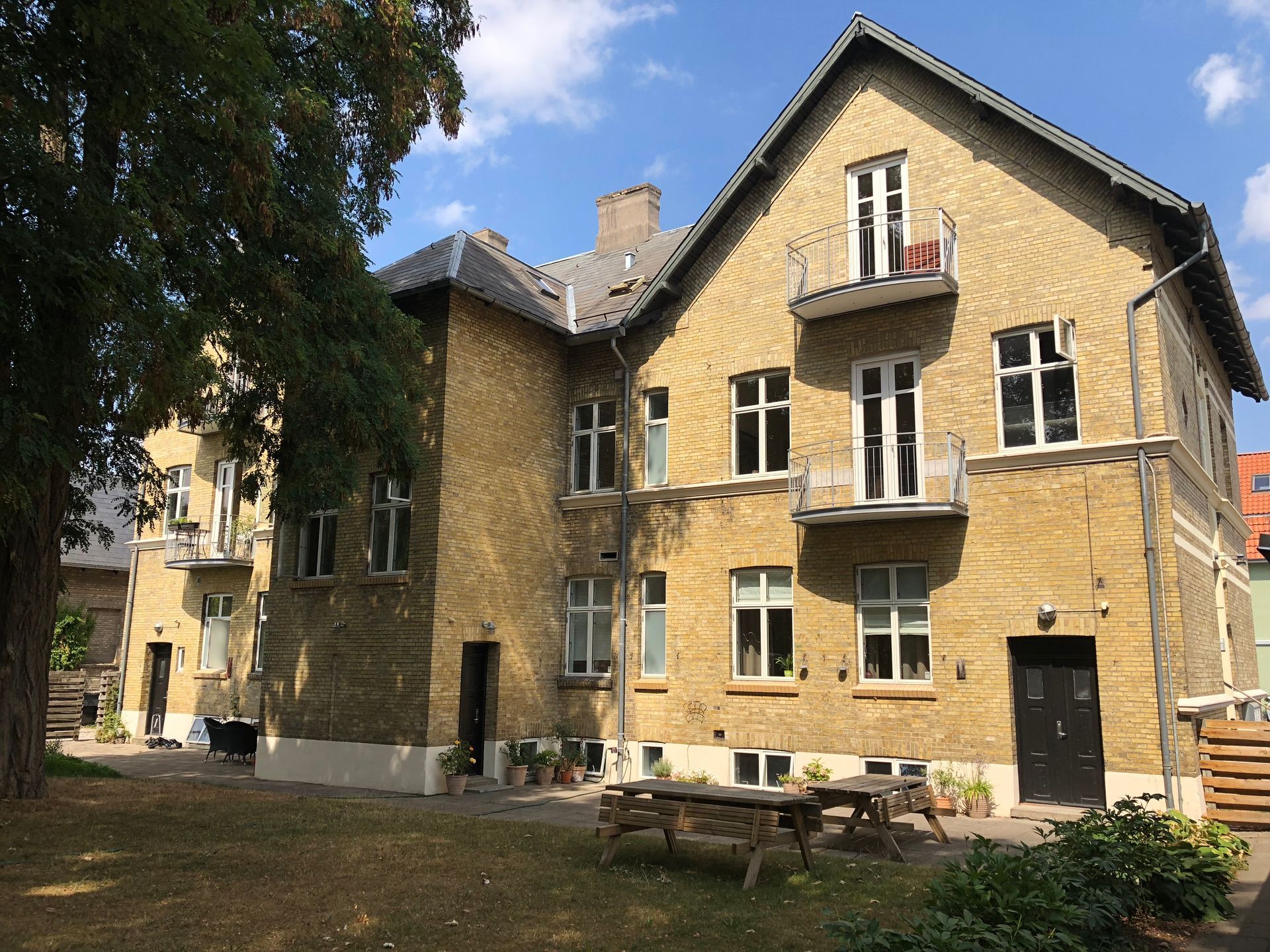 En stor murstensbygning med et picnicbord foran