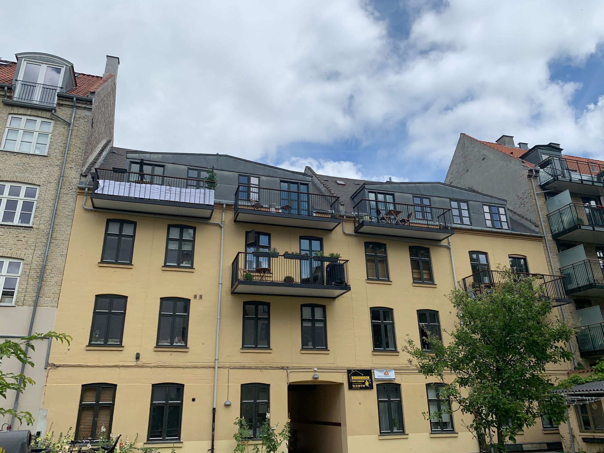 En gul bygning med en balkon på toppen af den
