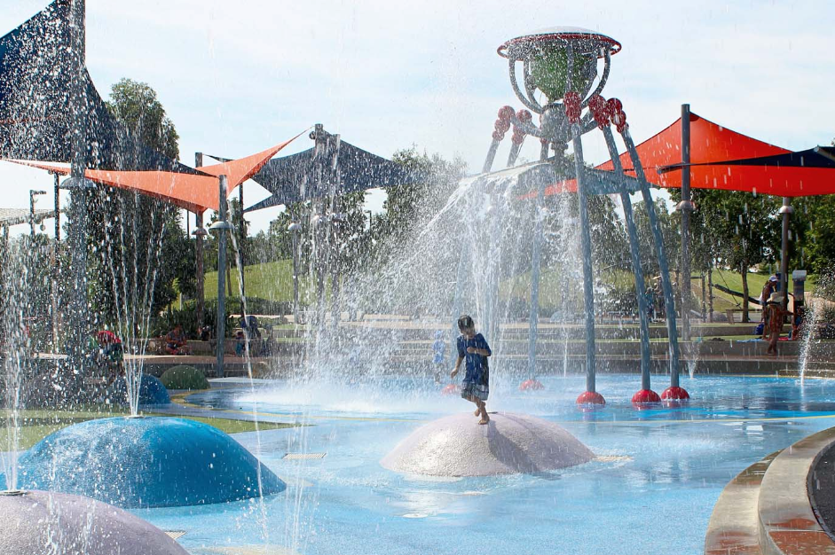 A young boy is playing in a water park