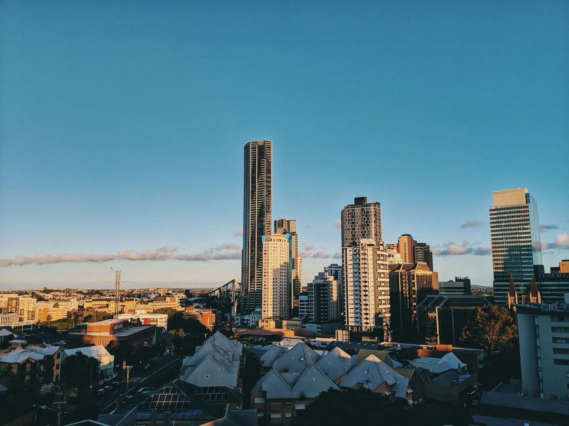 City skyline at sunset with tall modern buildings under a clear blue sky