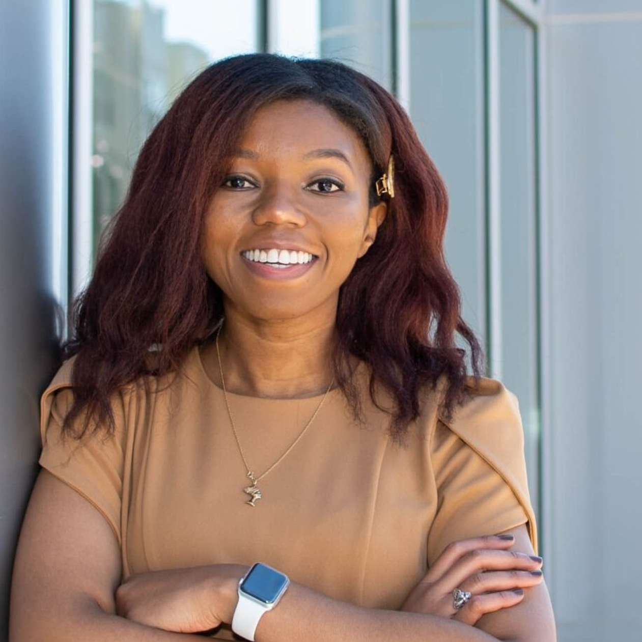 Artianna Singleton, LMFT | North Carolina Teletherapist, SG Therapeutic Services A woman in a brown dress is standing with her arms crossed and smiling.