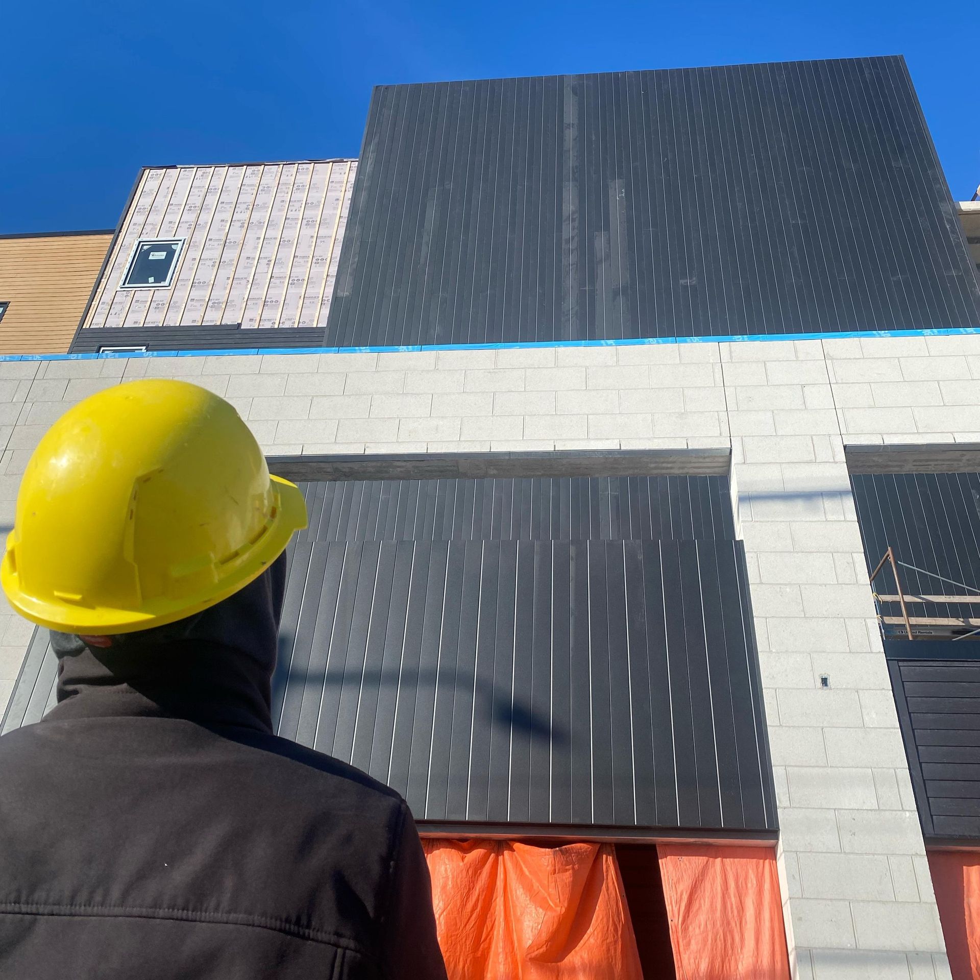 Siding installation in champlain building, crew looking up