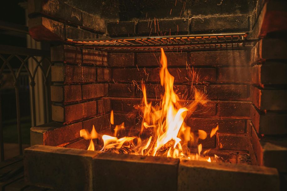 Brick fireplace with a bright orange flame burning inside