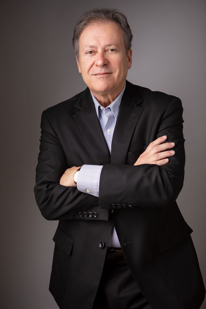 Man in suit, smiling, headshot.