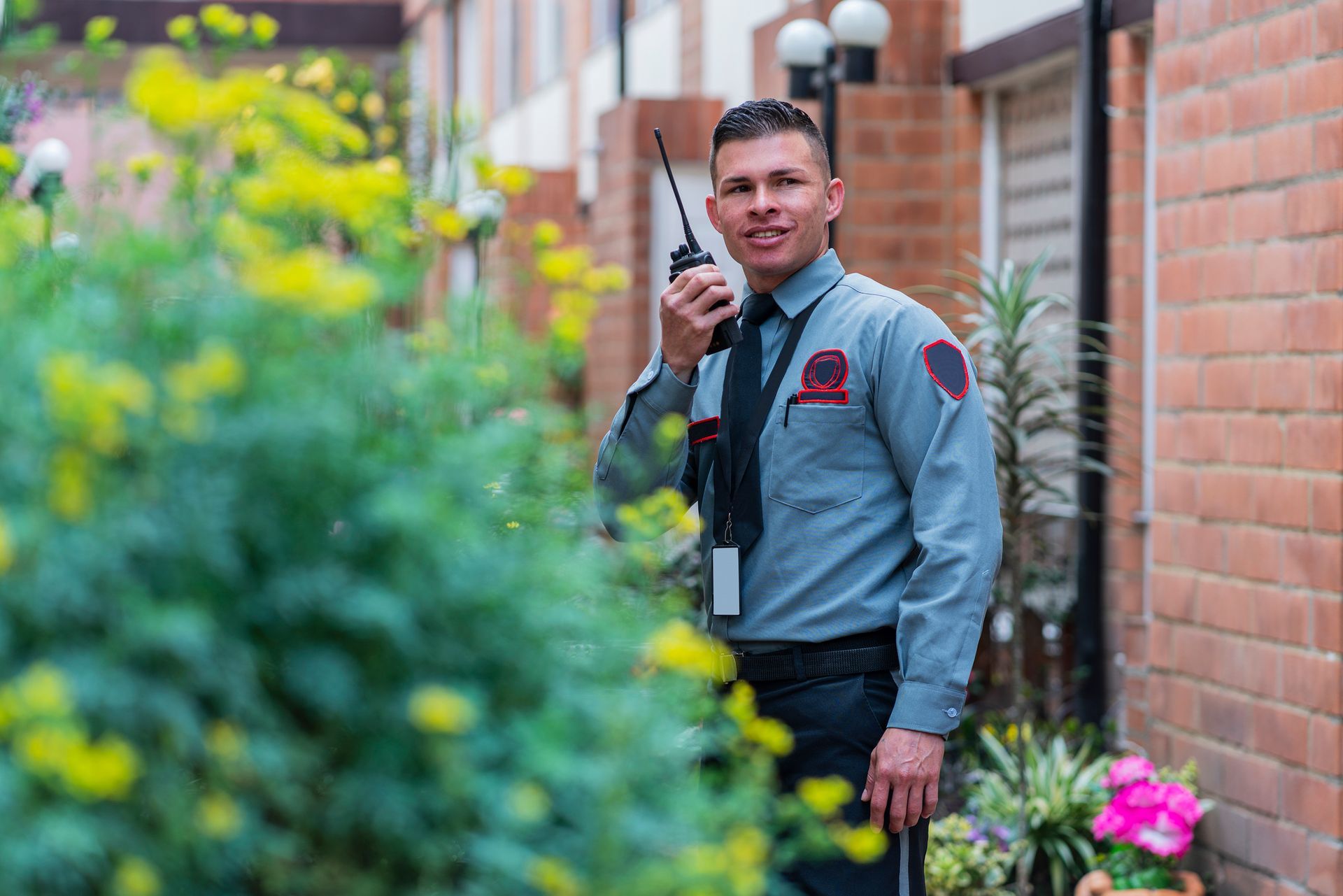 A Latino man security guard is making rounds by the houses.