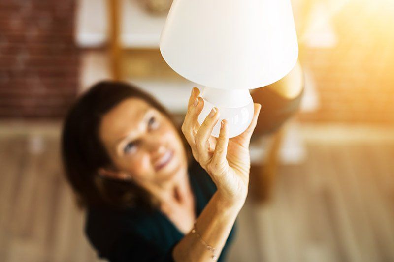 woman changing light bulb