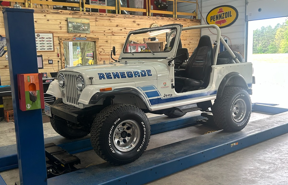 White Jeep Renegade on a lift in a garage, blue stripes, black interior, open top | Chip Ragans Auto, LLC