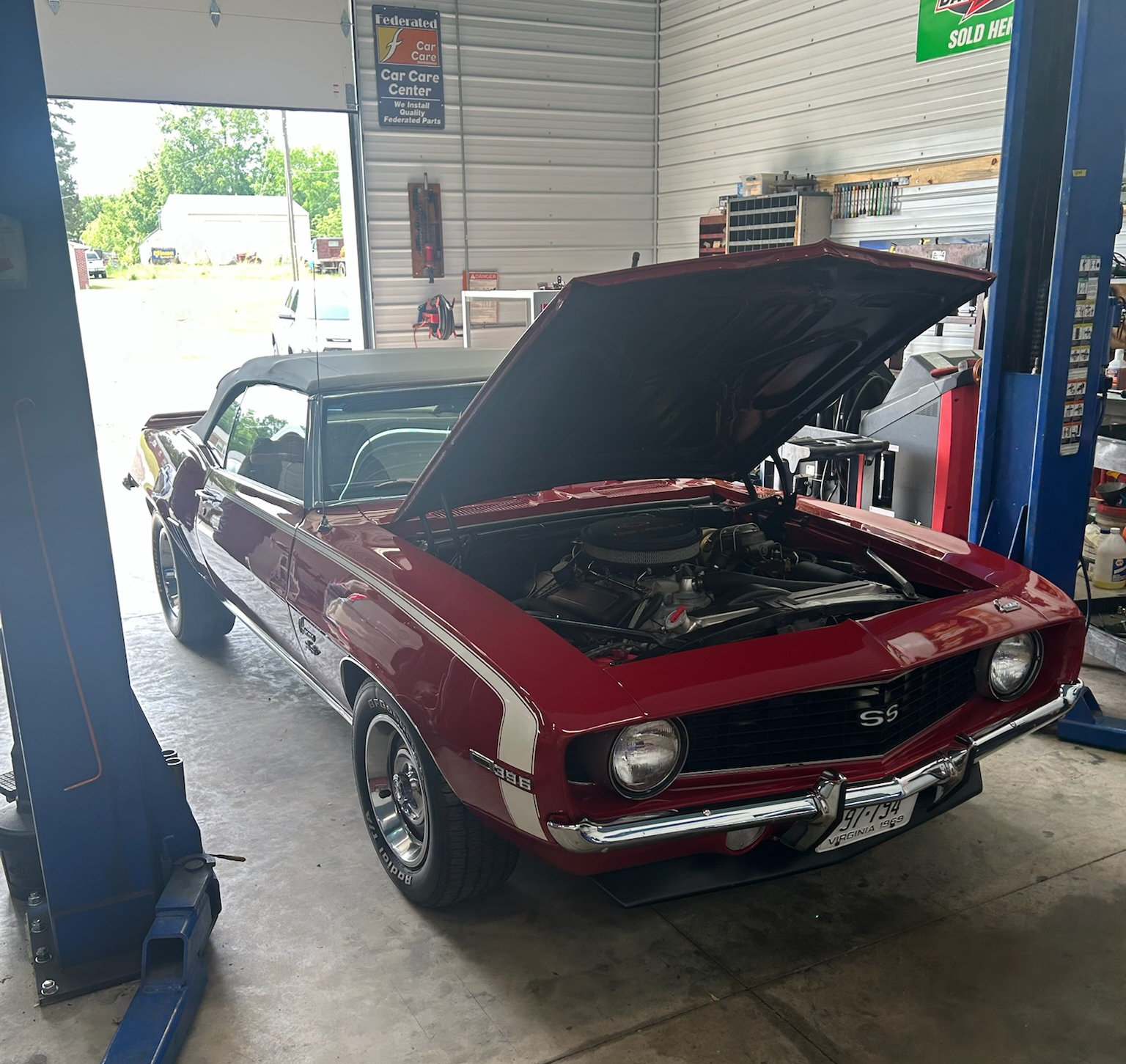 Red convertible classic car with open hood in a garage | Chip Ragans Auto, LLC