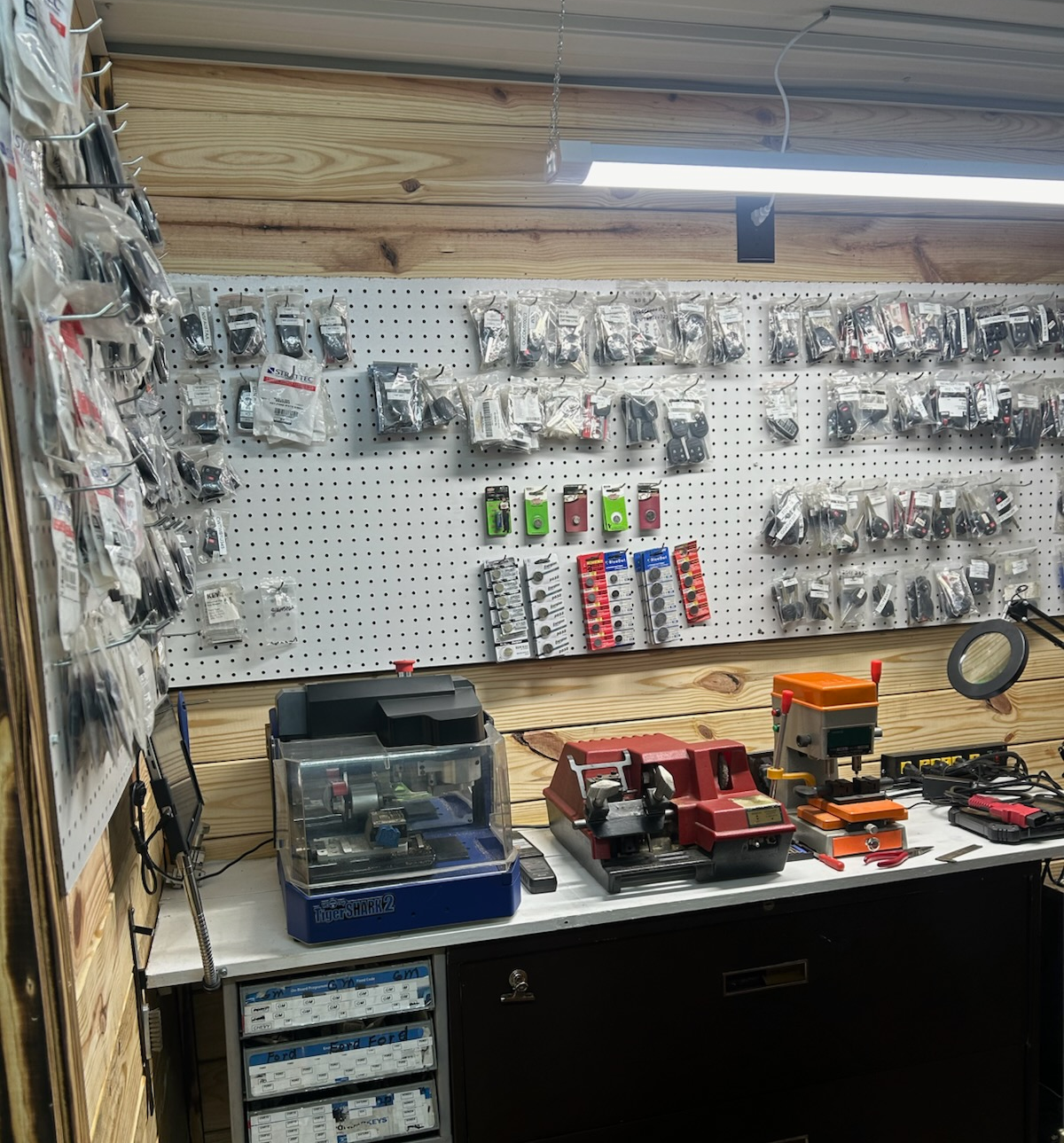 A locksmith's workspace with key-cutting machines, tools, and a display of key blanks | Chip Ragans Auto, LLC