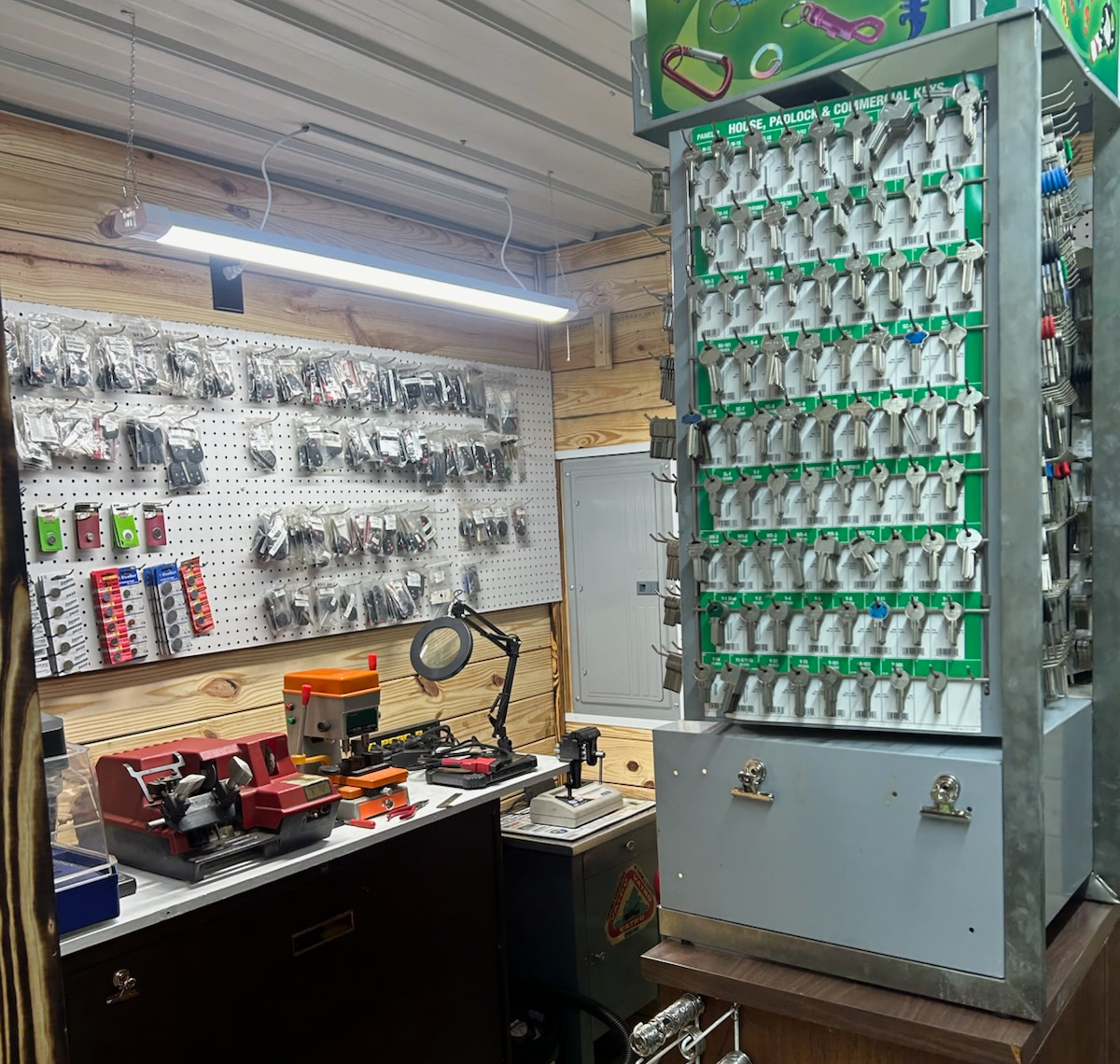 Key-cutting shop interior. Wall of keys, key-cutting machine, pegboard of key blanks, and a safe | Chip Ragans Auto, LLC