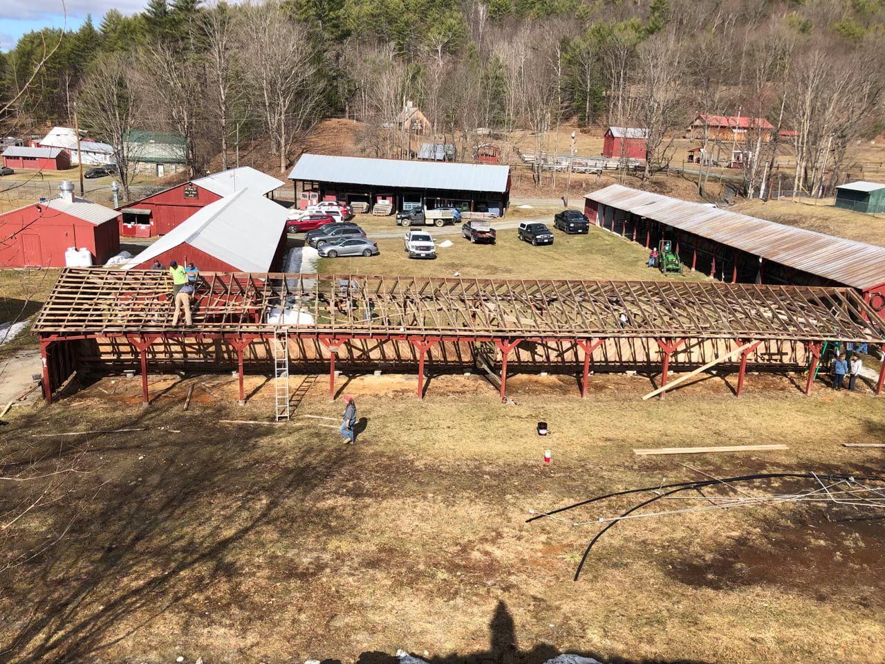 An aerial view of a large barn being demolished.