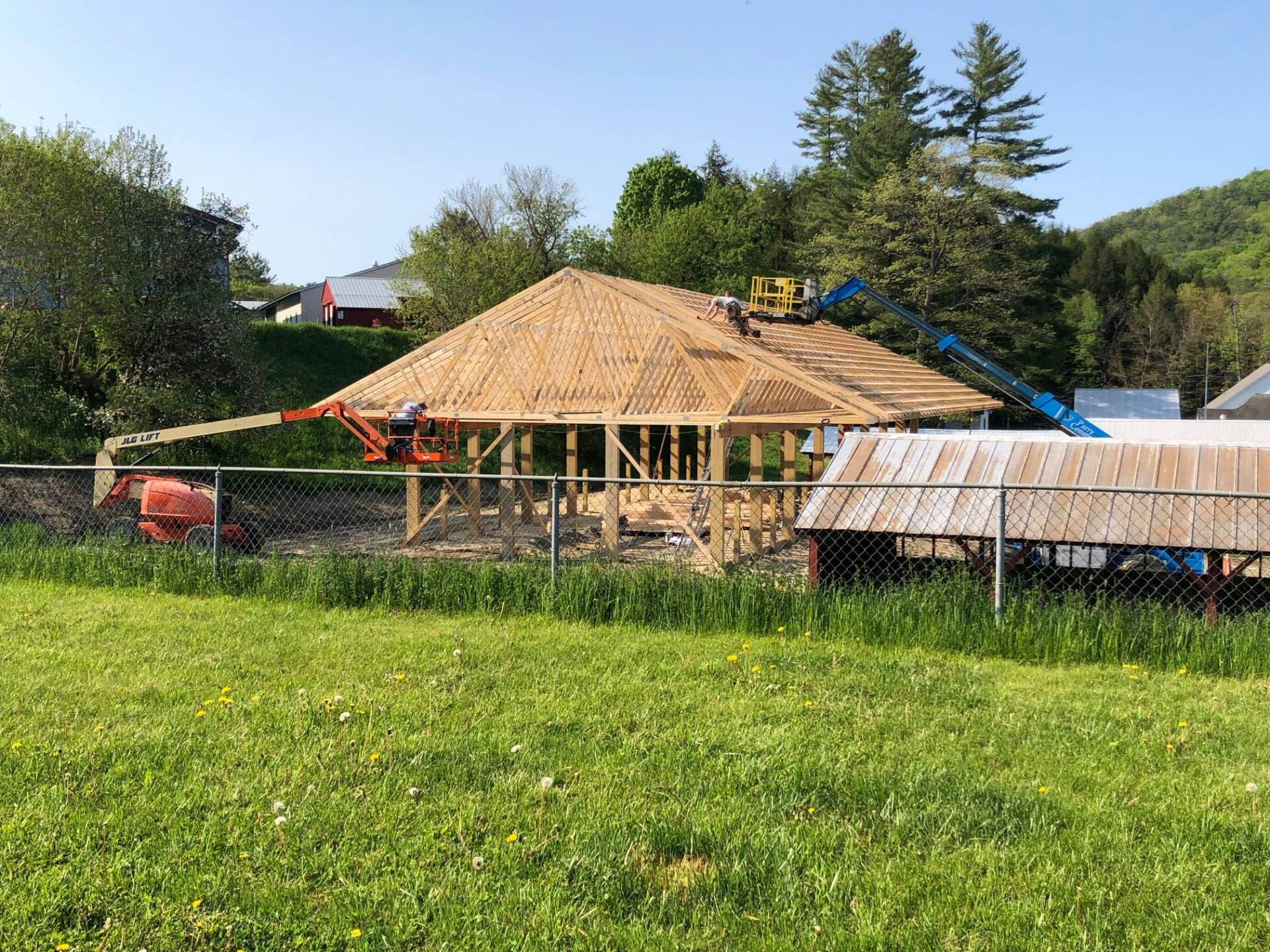 A house is being built in a grassy field.