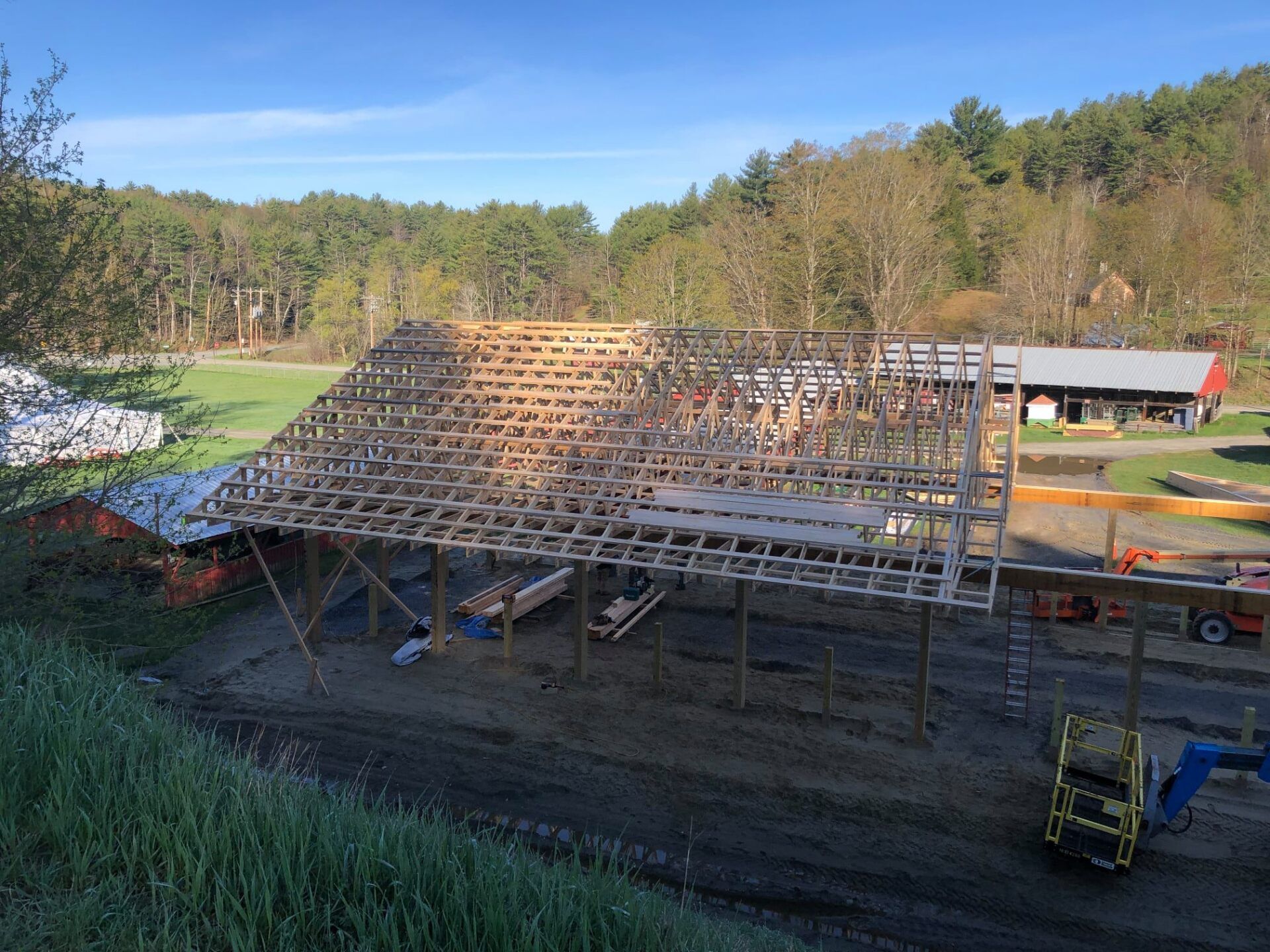 A large wooden structure is being built in the middle of a field.