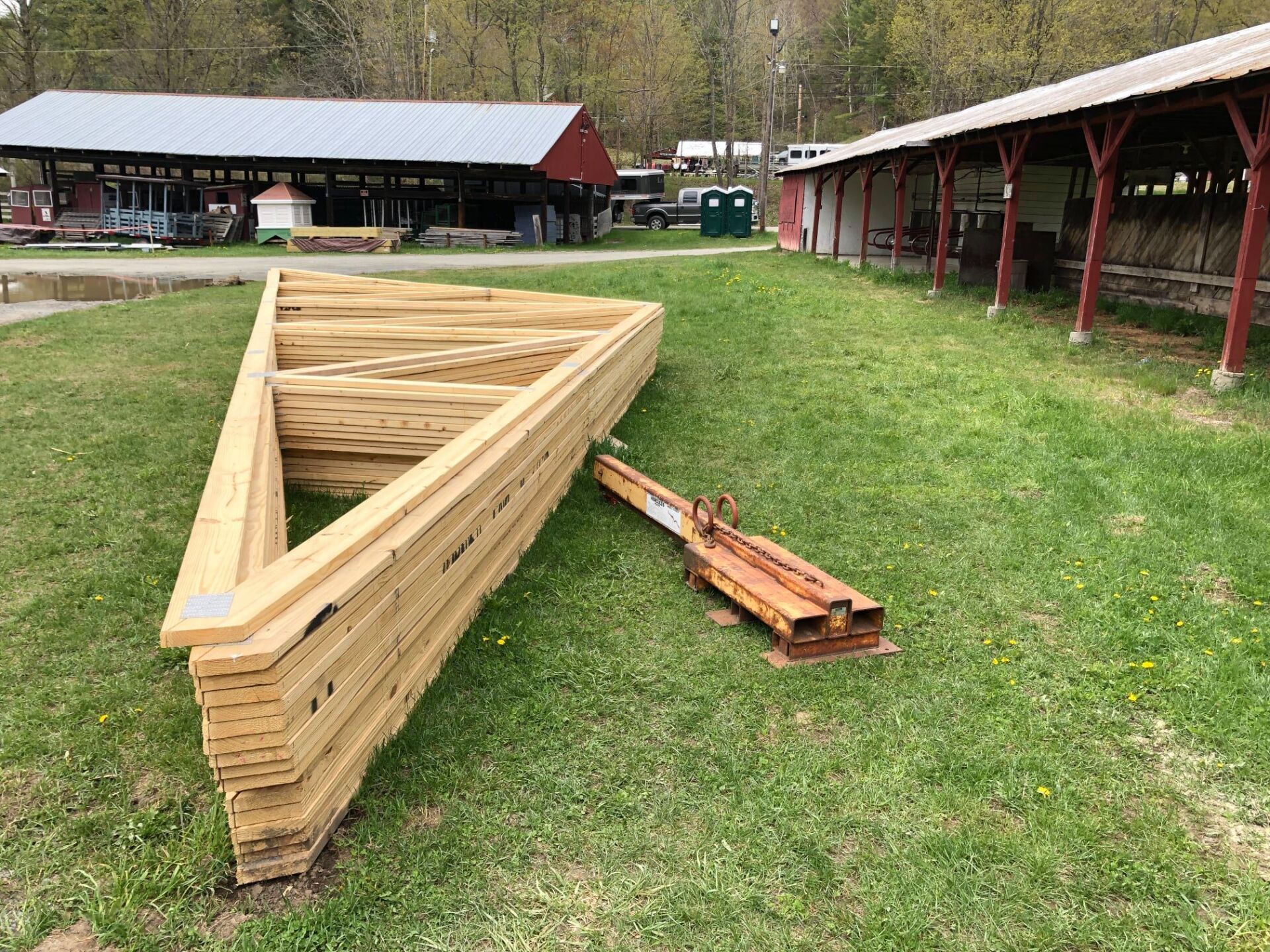A large triangle of wood is sitting on top of a lush green field.