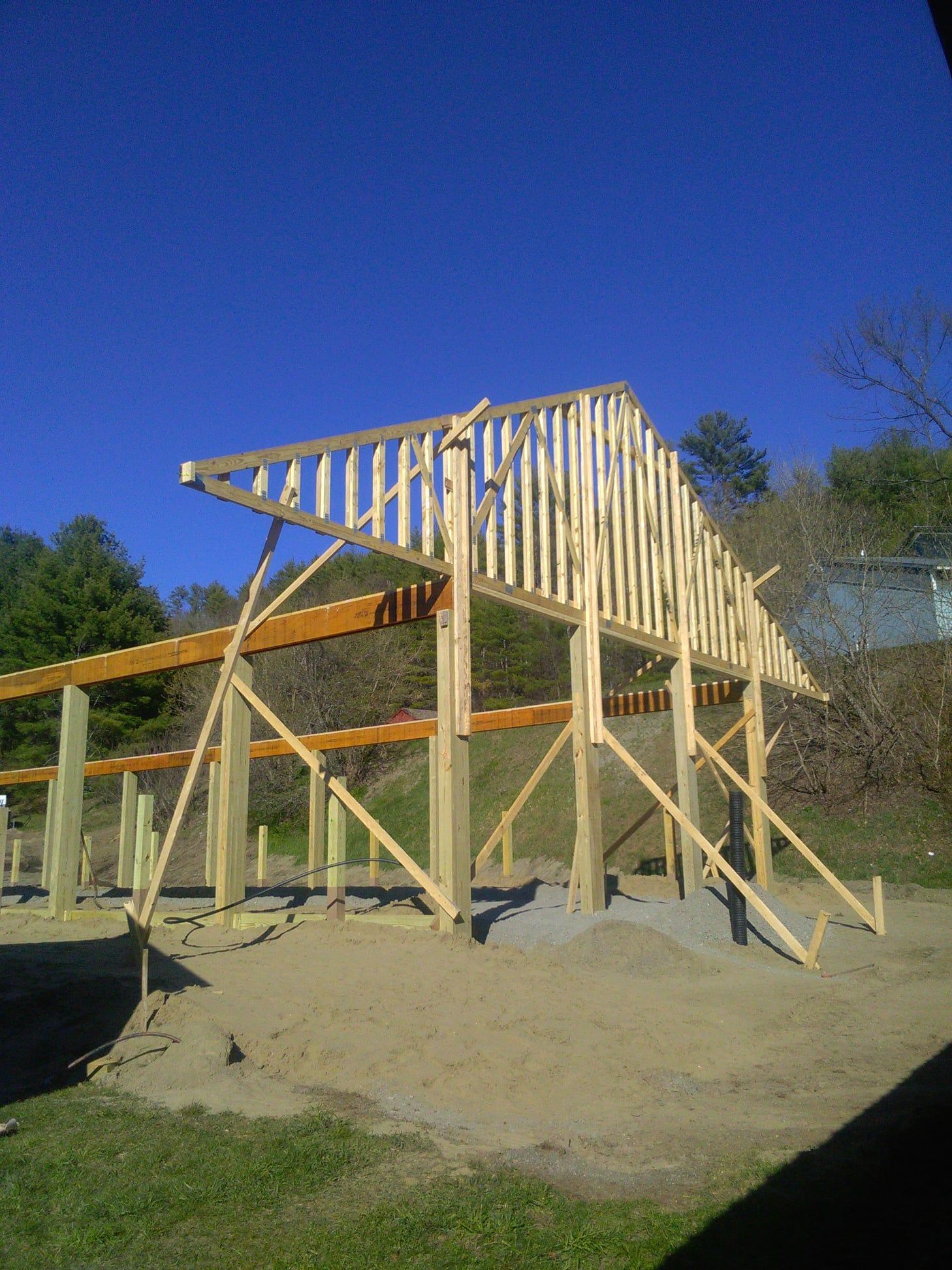 A large wooden structure is being built in a field