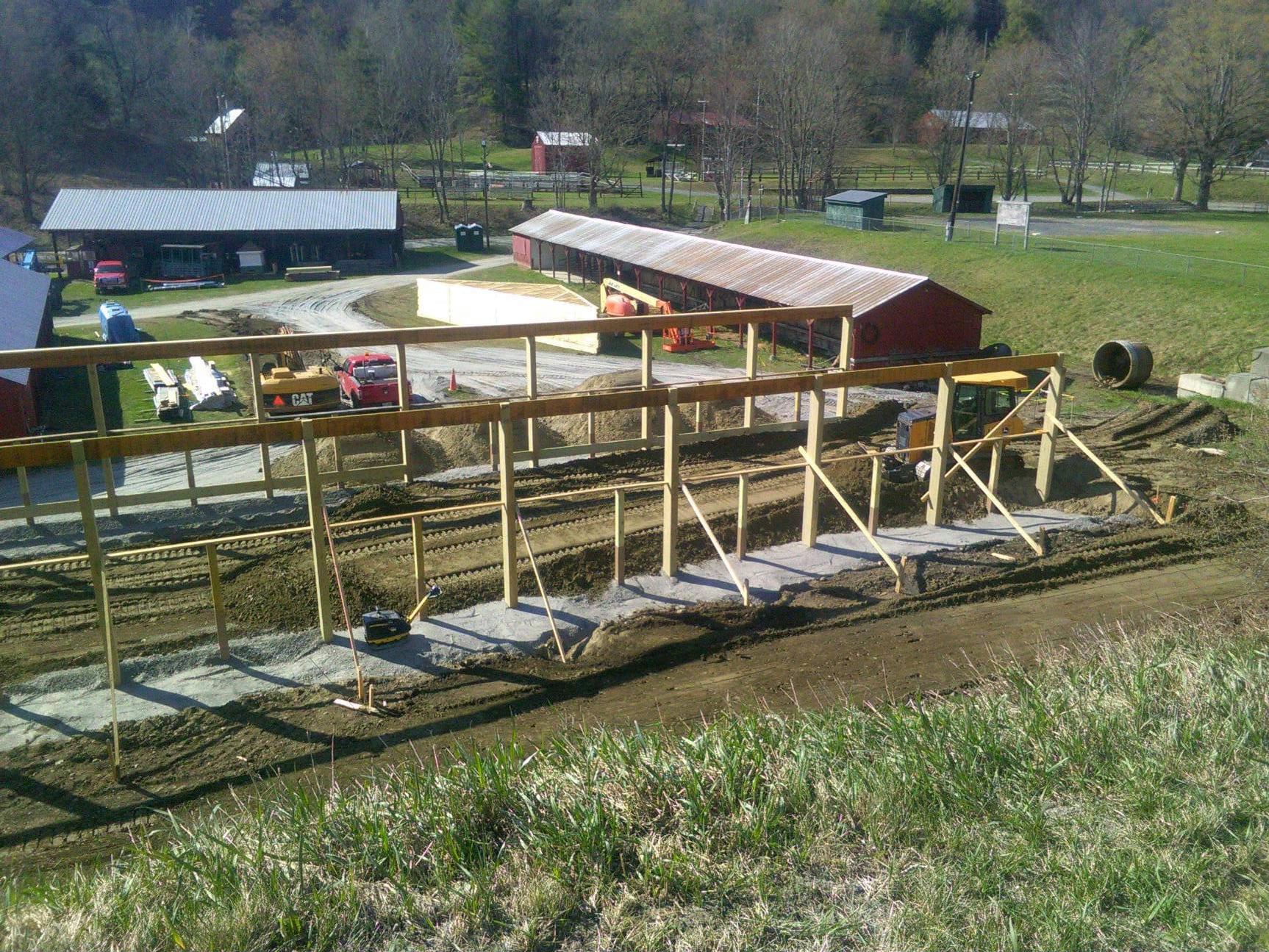 A wooden structure is being built in a field