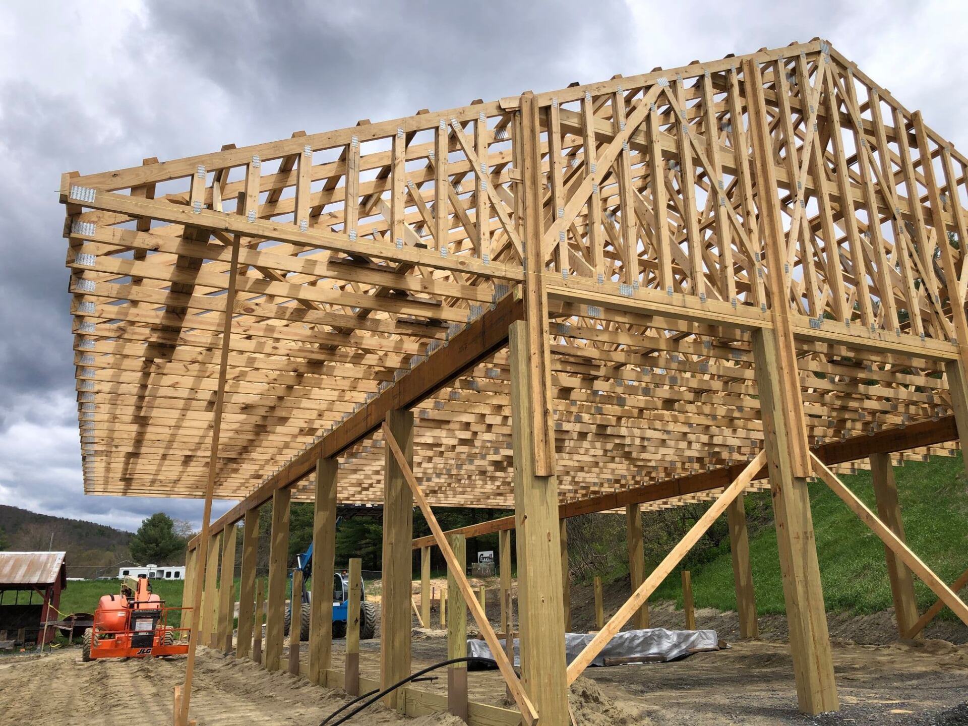 A large wooden structure is being built in a field.