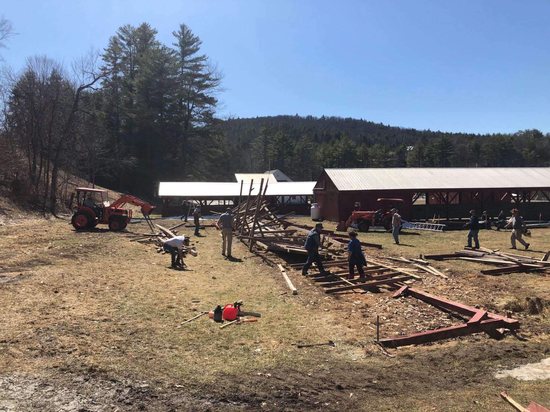 A group of people are working in a field in front of a building.